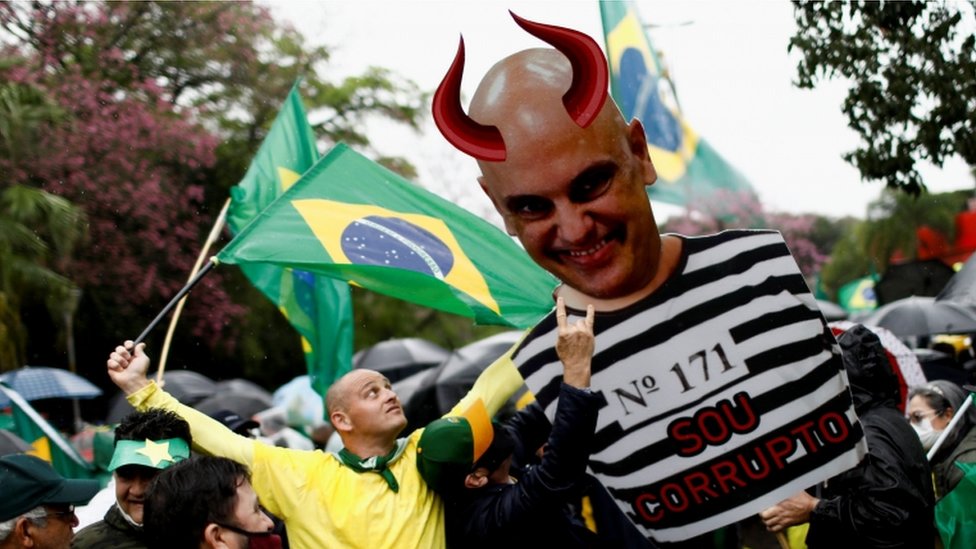 Manifestantes seguram grande imagem de Alexandre de Moraes com chifres e dizeres: Sou corrupto