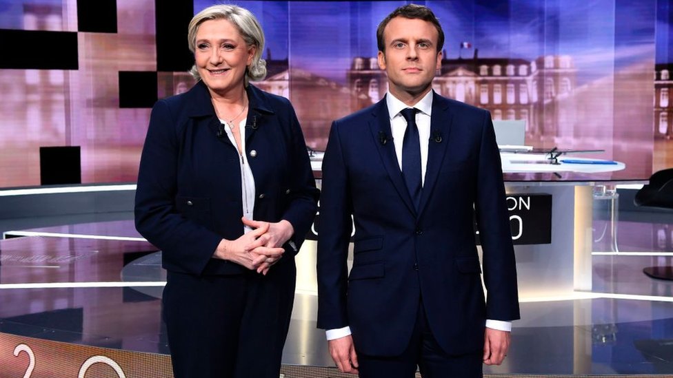 French presidential election candidate Marine Le Pen (L) and Emmanuel Macron pose prior to the start of a live election debate on May 3, 2017