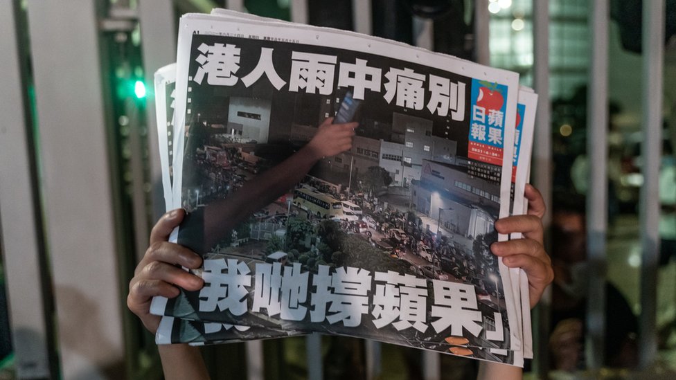 香港將軍澳壹傳媒總部大樓外一名《蘋果日報》僱員舉起最後一期報紙（24/6/2021）