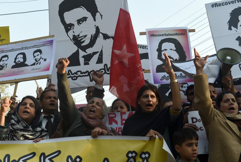 Пакистанские правозащитники держат фотографии пропавших без вести блоггеров во время акции протеста в Лахоре 12 января 2017 года.