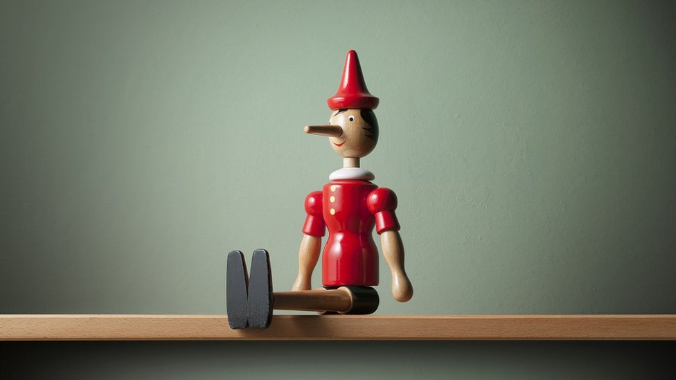 A wooden Pinocchio figurine, sitting on a shelf
