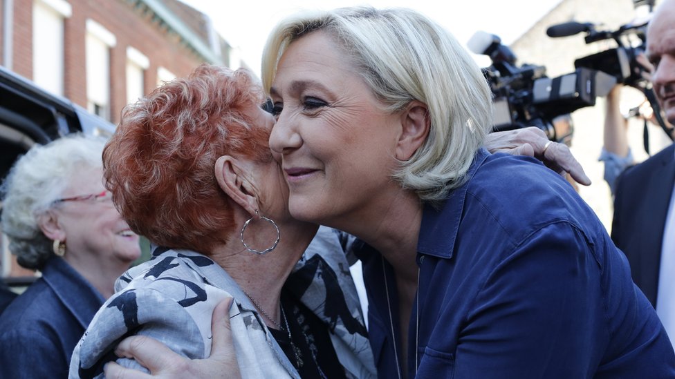 Марин Ле Пен приветствует сторонников, покидая избирательный участок после того, как проголосовала за Энен Бомон.