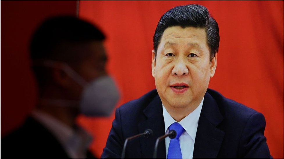 Un hombre ve una pantalla en la que se ve a Xi Jinping.