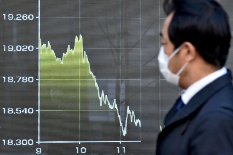 Tokyo'da Nikkei endeksindeki düşüşü gözlemleyen bir Japon