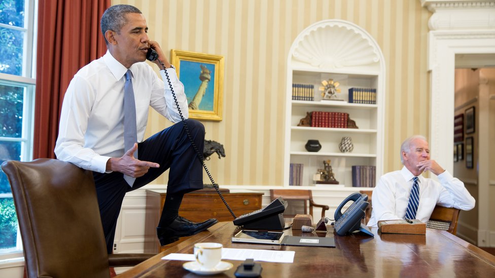 Барак Обама разговаривает по телефону со спикером Палаты представителей Бонер, пока вице-президент Джо Байден слушает в Овальном кабинете, 31 августа 2013 г.