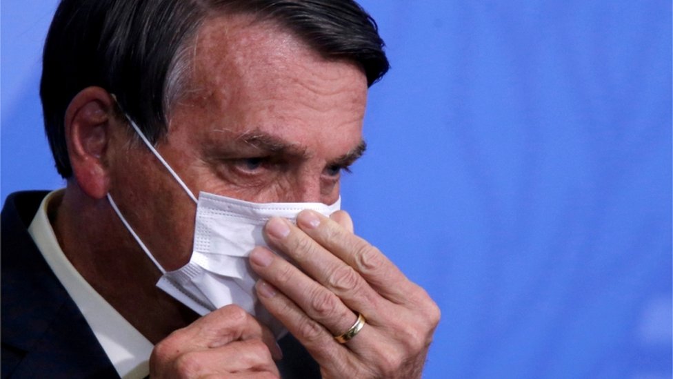 Jair Bolsonaro colocando máscara