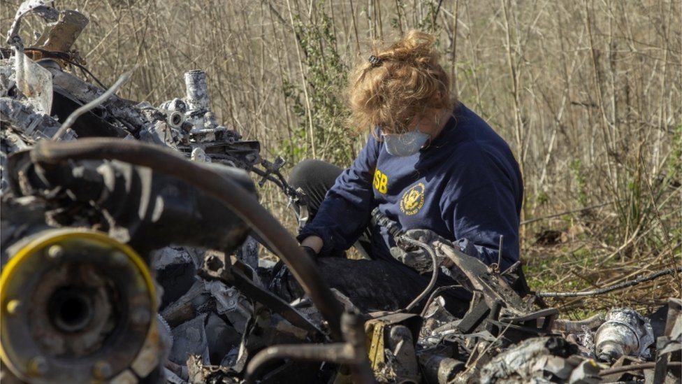 An investigator works at the scene of the helicopter crash that killed former NBA star Kobe Bryant