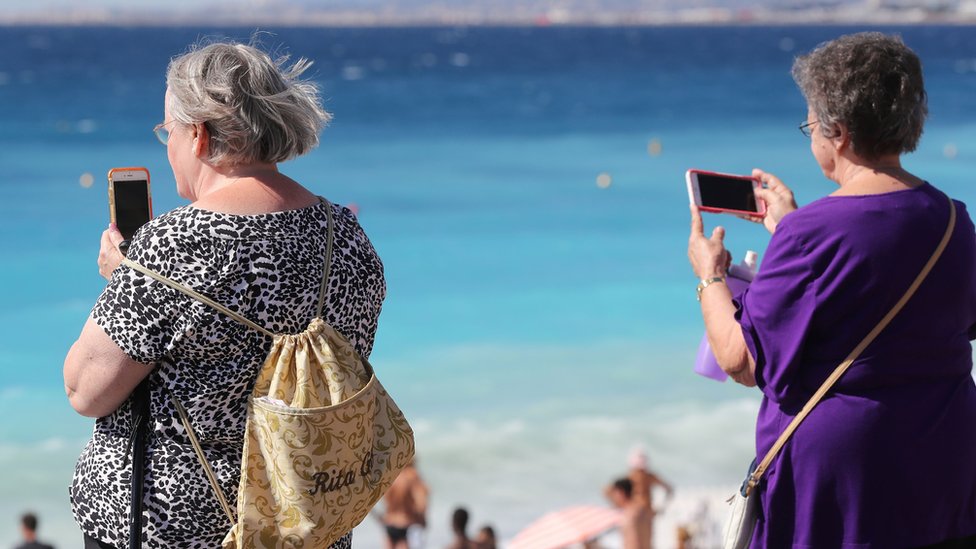Две женщины используют свои мобильные телефоны во Франции