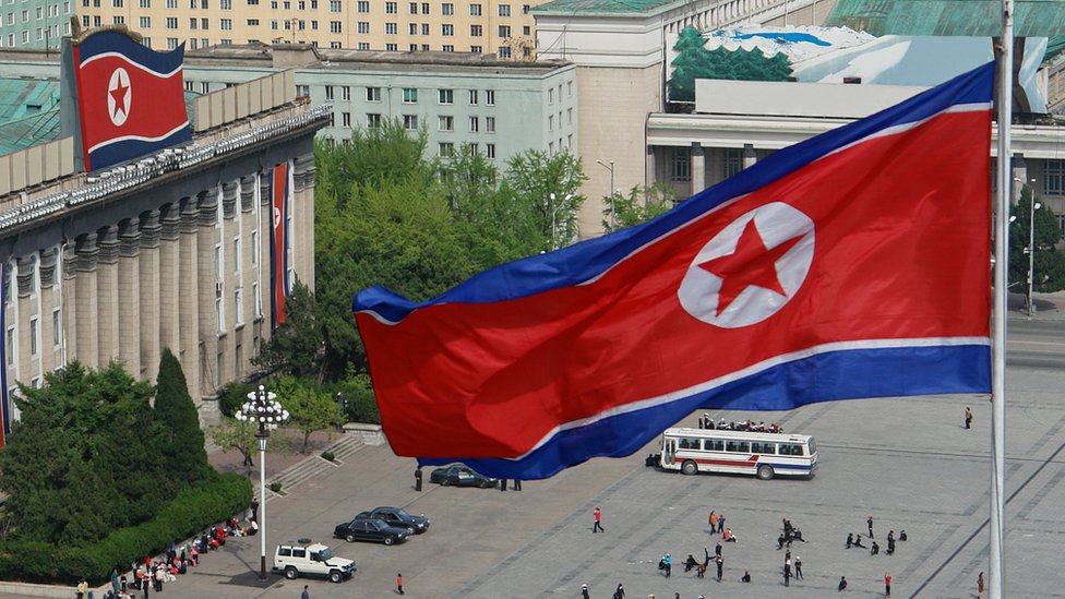 Флаги Северной Кореи развеваются над зданиями на площади Ким Ир Сена в Пхеньяне