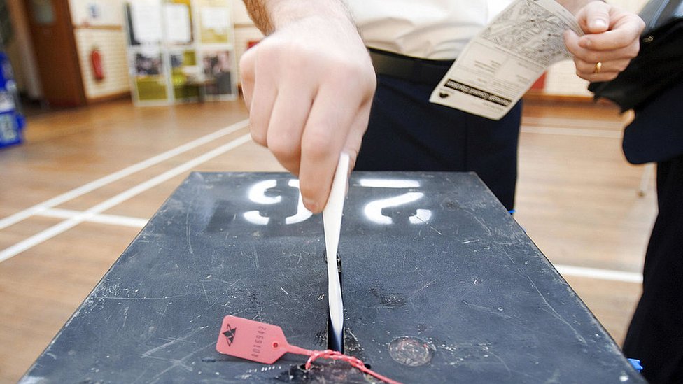 Un hombre votando en elecciones generales en Reino Unido.