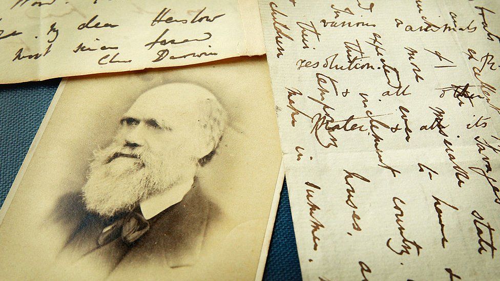 Una foto de Darwin con unas cartas