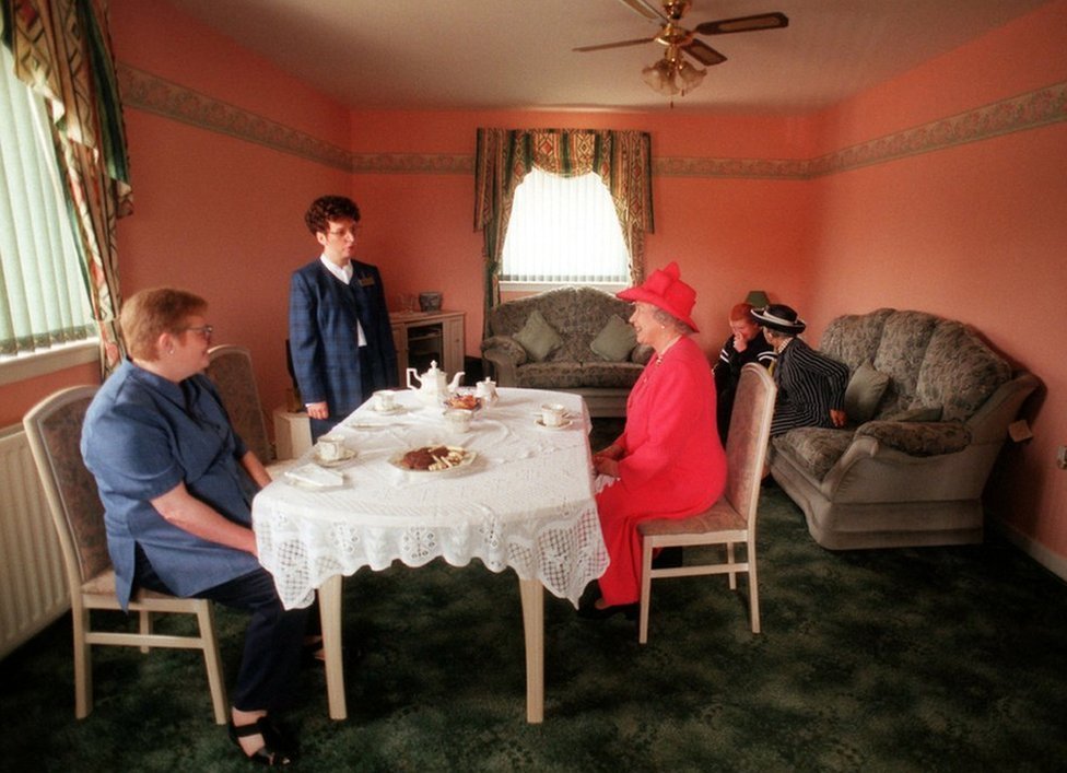 La reina se unió a Susan McCarron (al frente a la izquierda), su hijo de 10 años, James y la gerente de Vivienda Liz McGinniss para tomar el té en su casa en el área de Castlemilk en Glasgow, el 7 de julio de 1999.