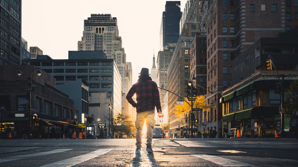 Un hombre de espaldas parado en una calle vacía de Nueva York.