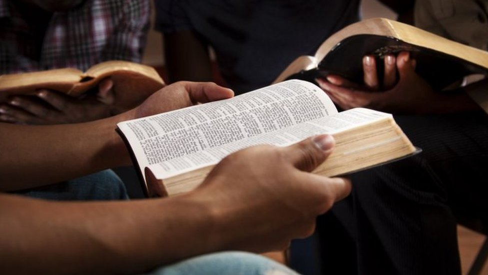Uma pessoa segurando uma Bíblia aberta