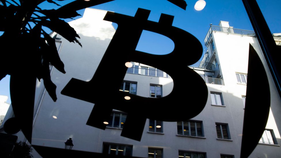 Логотип биткойна на окне в La Maison du Bitcoin в Париже