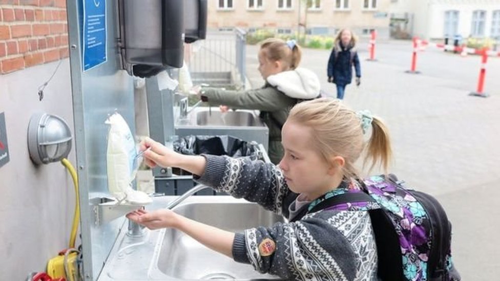 дети моют руки в уличных раковинах