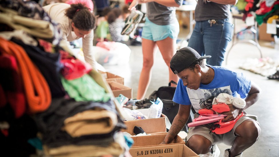 Люди сортируют пожертвованную одежду в Общественном центре Лейк-Чарльза в Лейк-Чарльз, штат Луизиана, 31 августа 2017 года.
