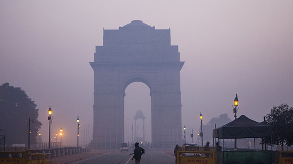 Police officers stand guard at the India Gate monument shrouded in smog in New Delhi, India. Photographer: Prashanth Vishwanathan/Bloomberg