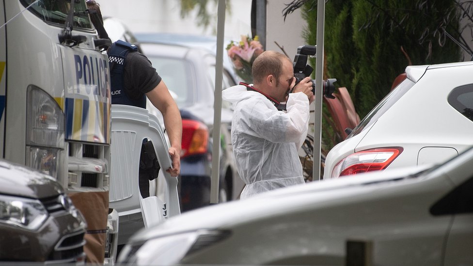 مصور من الشرطة النوزيلندية يلتقط صورا في موقع الهجوم.