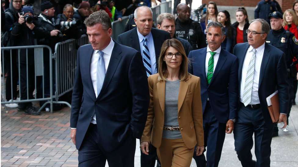 La actriz Lori Loughlin (centro) y su esposo Mossimo Giannulli (de corbata verde) a la salida del tribunal en Boston, 3 de abril, 2019