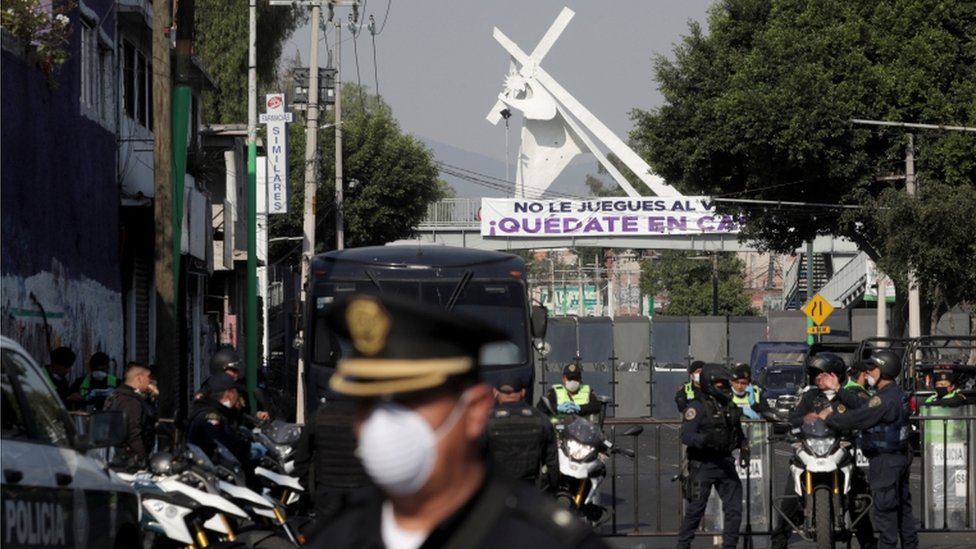 La calle de acceso a una iglesia en Ciudad de México está bloqueada y custodiada por policías.