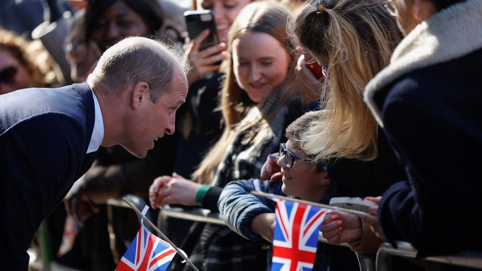 Prince William speaks to a child in the crowd.