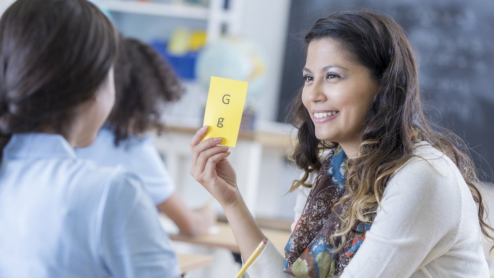 Los disléxicos tienen dificultades para leer, pero ningún impedimento físico o mental que lo explique. Mujer enseñando a leer a niño
