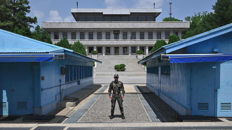 Южнокорейский солдат стоит на страже перед военной демаркационной линией (MDL) во время регулярного турне для СМИ в приграничную деревню перемирия Панмунджом в демилитаризованной зоне