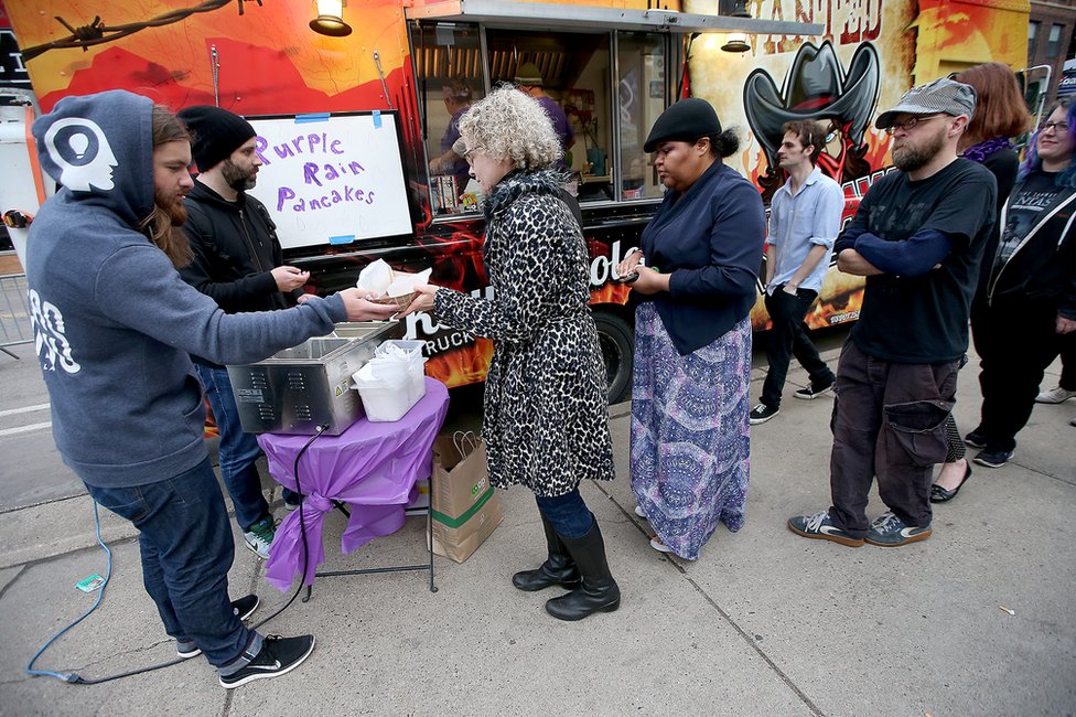 Гарри Трепет (слева) и Джош Комбс бесплатно раздают "Блины с пурпурным дождем" возле клуба на Первой авеню в Миннеаполисе, 22 апреля