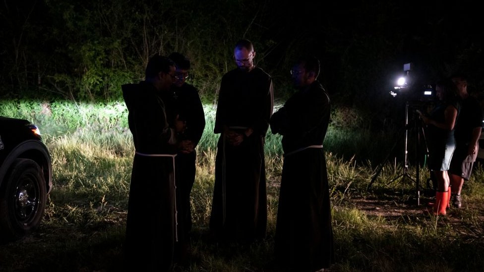 Sacerdotes de la Arquidiócesis de San Antonio rezan en el lugar de la tragedia.