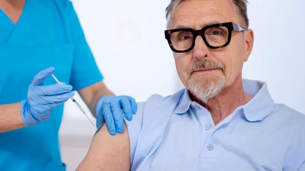 stariji muškarac prima vakcinu