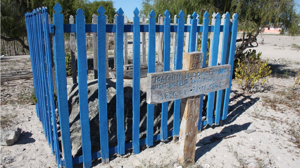 Деревянный крест и синий забор отмечают могилу кораблестроителя Людовика Эммануэля Иоахима, умершего в 1902 году.