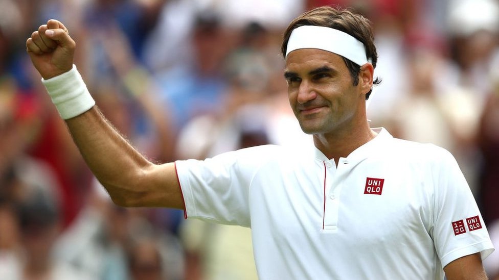 Roger Federer levanta el brazo.