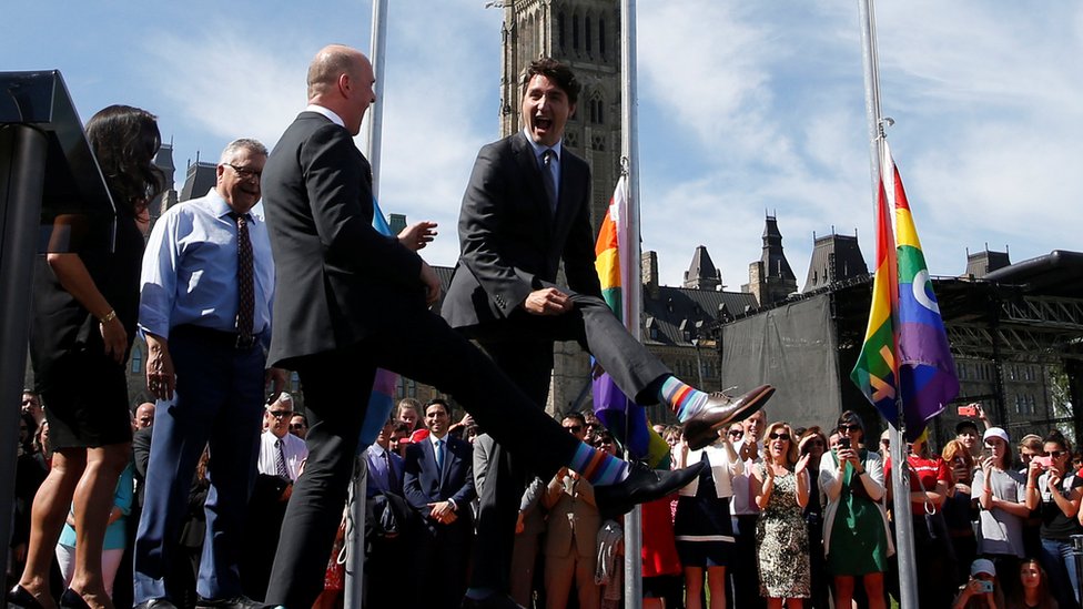 Премьер-министр Канады Джастин Трюдо сравнивает носки с депутатом-либералом Рэнди Буассонно во время церемонии поднятия флага гордости на Парламентском холме в Оттаве, Онтарио, 25 июня 2017 г.