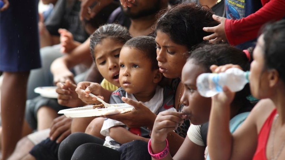 Венесуэльские мигранты едят по прибытии на пляж Лос-Ирос после возвращения на остров, в Эрин, Тринидад и Тобаго, 24 ноября 2020 г.