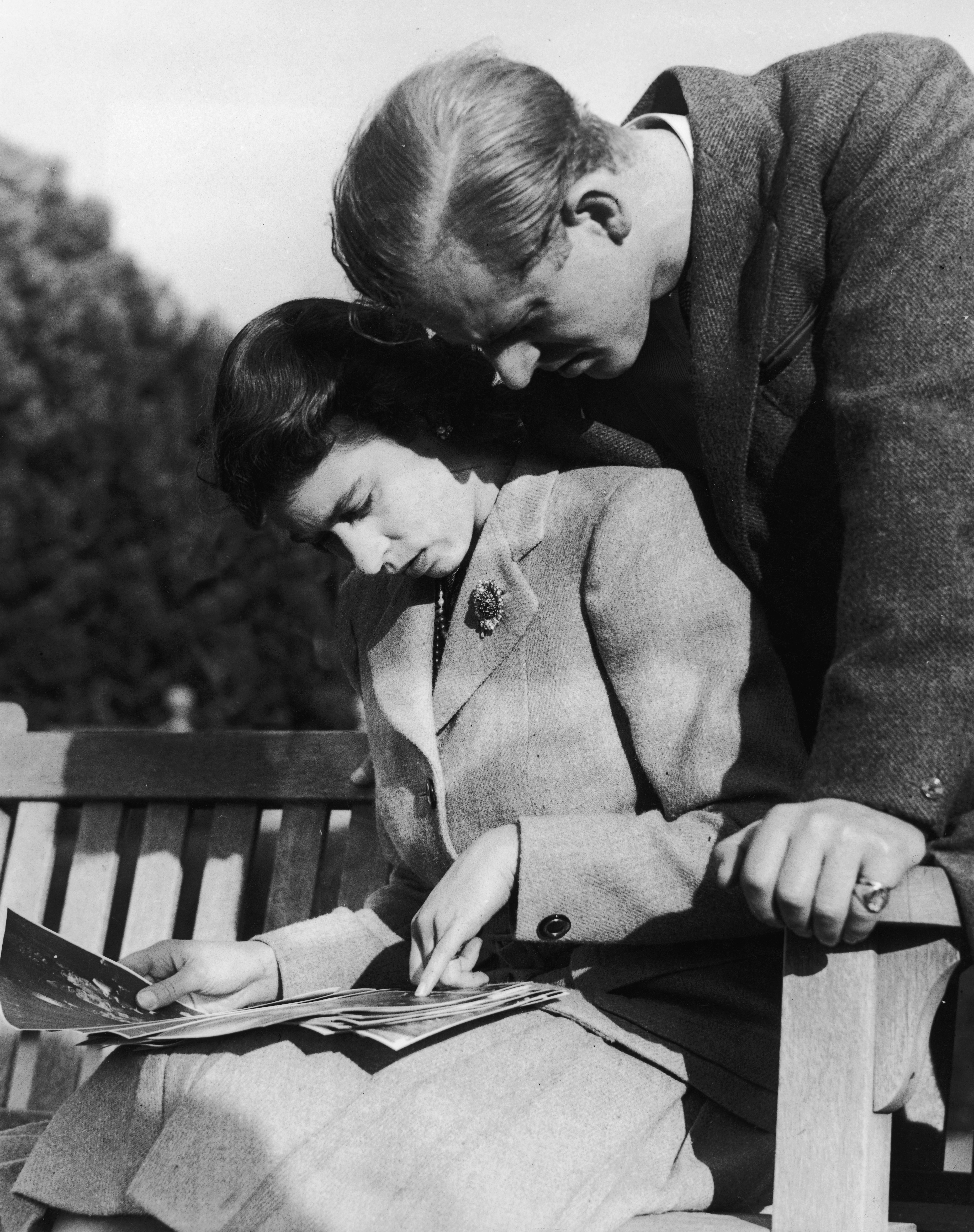 Princess Elizabeth and Prince Philip look through a photo album during their honeymoon in Hampshire on November 23, 1947.