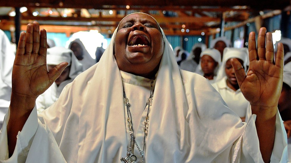 Женщина молится в церкви в Кении - архивный снимок