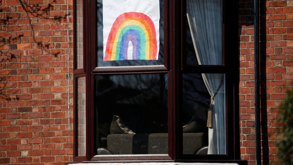 Нарисованное от руки изображение радуги видно в окне в Ливерпуле, поскольку распространение коронавирусной болезни (COVID-19) продолжается. Ливерпуль, Великобритания