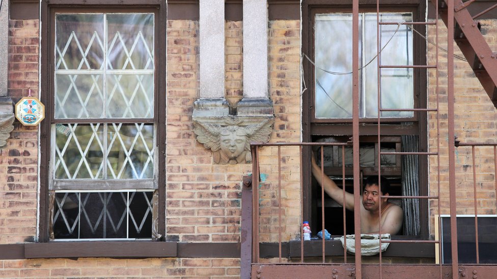 Мужчина смотрит в окно в Нью-Йорке