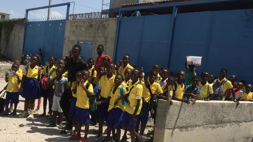 Children in school uniforms in Cité Soleil waiting for a lift