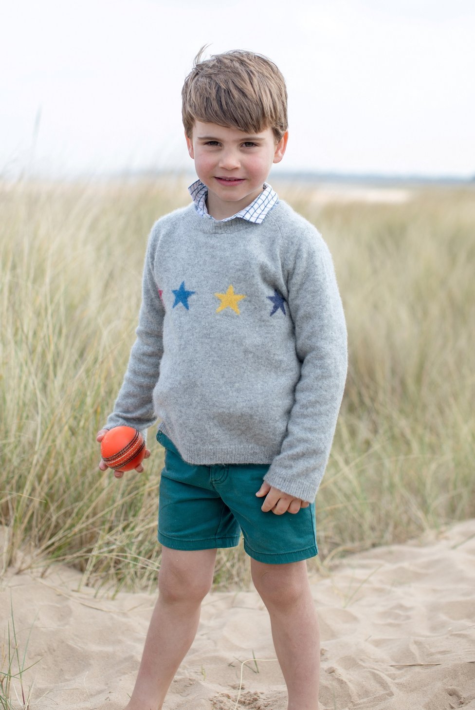 Príncipe Louis está descalço na areia em Norfolk