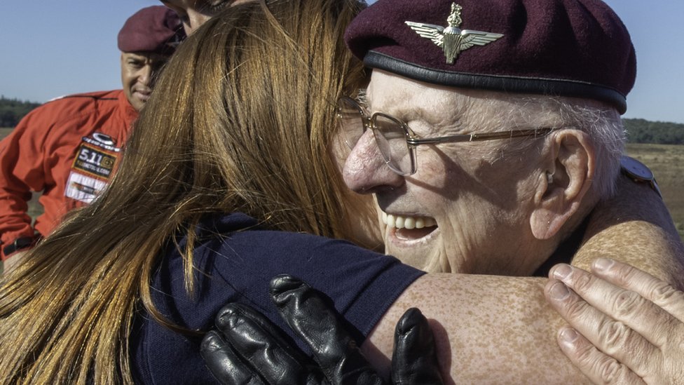 97-летний ветеран Сэнди Кортманн обнимается со своей опекой, Арлин Кэмпбелл, сразу после прыжка в тандеме.