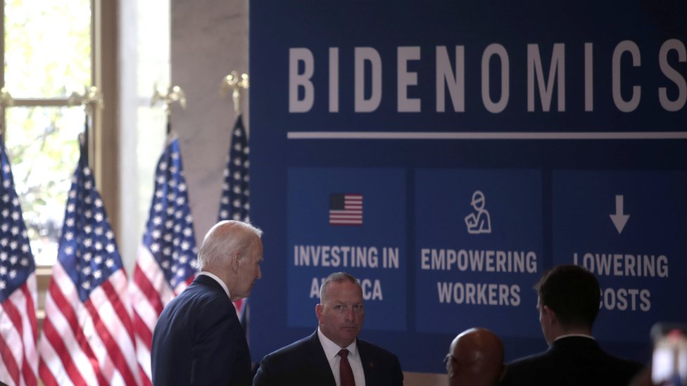Biden in front of sign that reads: Bidenomics