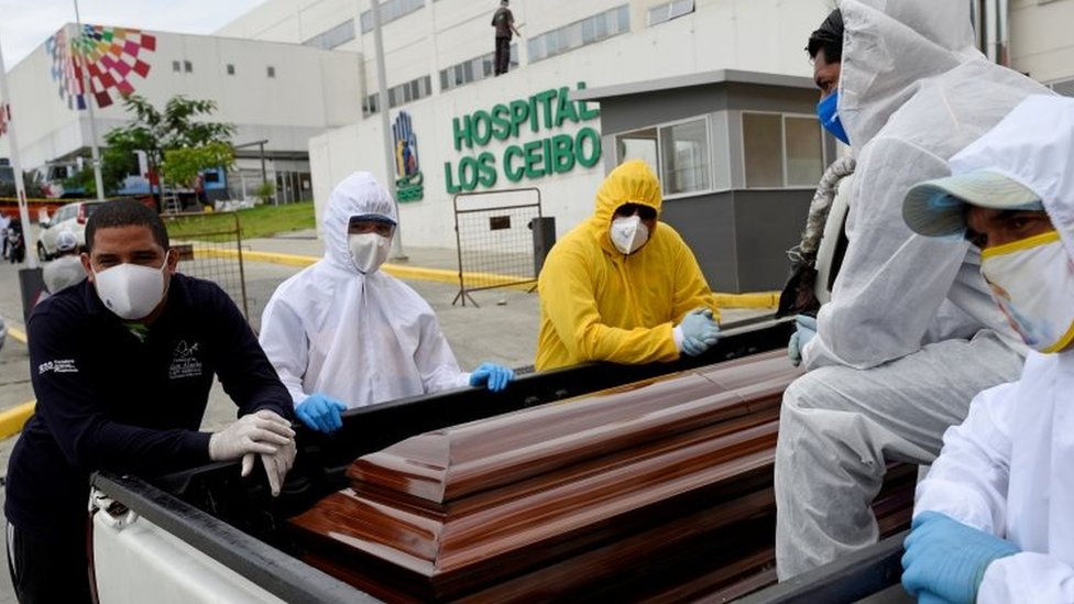 Mortuary workers carry a coffin