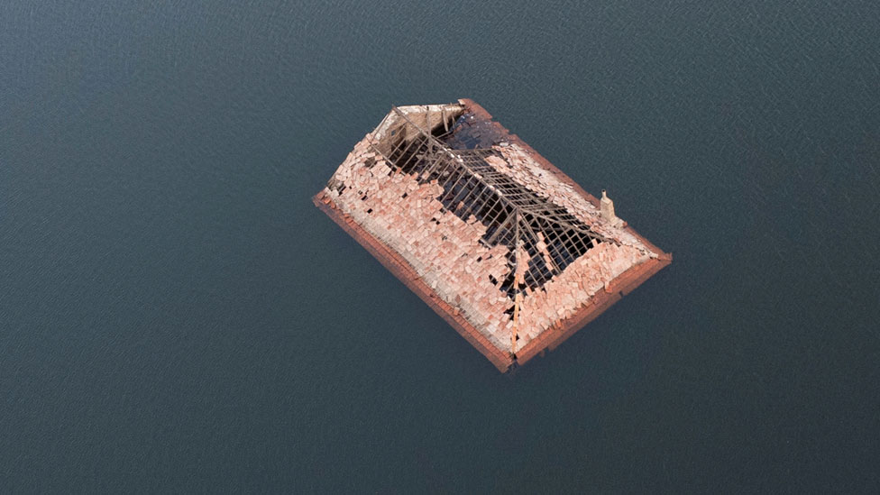 Techo derruido de una casa cubierta por el agua del lago