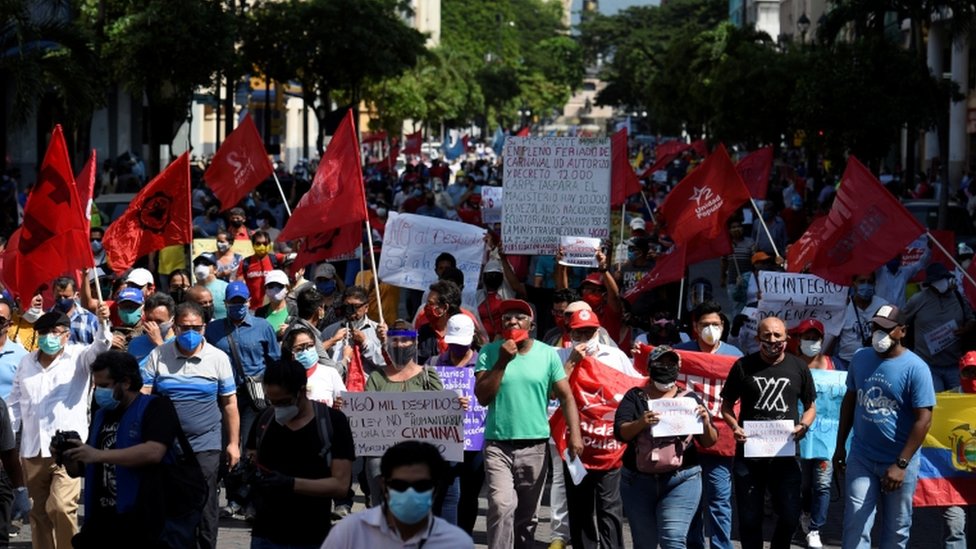 Протестующие с флагами и транспарантами маршируют в Гуаякиле