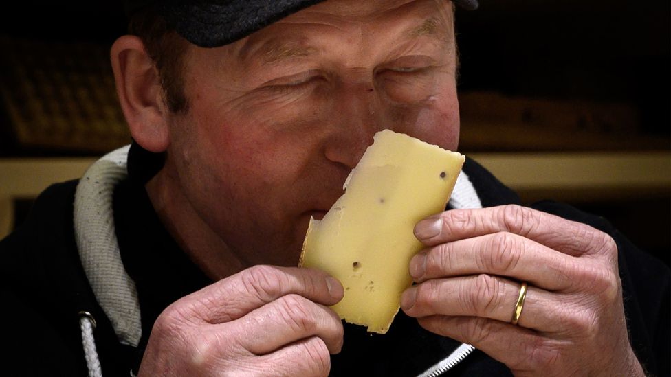 Homem cheirando queijo
