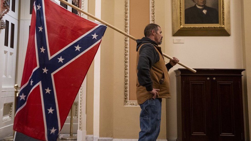 A protester carries the Confederate flag into the US Capitol building