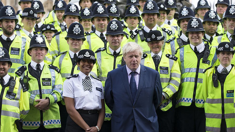 Борис Джонсон стоит с десятками полицейских