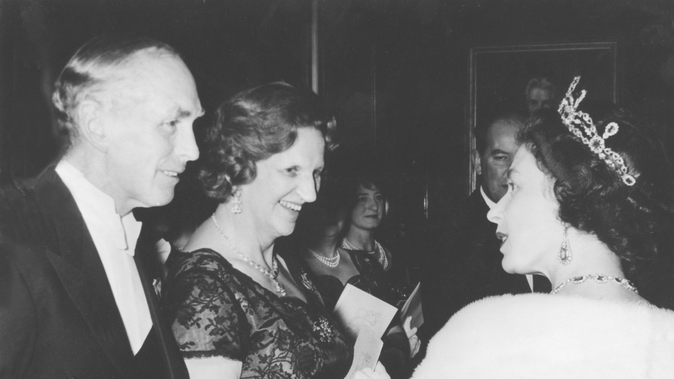 1964年，女王在一次宴會上與首相阿勒克·道格拉斯-霍姆及夫人說話。